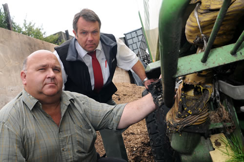 (L to R) Member Andrew Dinnis with Cornish Mutual Inspector Gary Burgess inspecting the damage of a recent baler fire at his Talaton farm