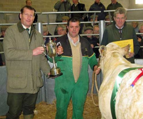 Keith Webb (left) of Santander,  presents Barry Tomlinson, owner of champion beast, with the Auctioneers Perpetual Challenge Cup watched by Peter Willcock, chairman of Halls.