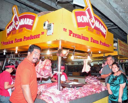 Mr Boni Ong and his wife, Maritess (right) with  their meat operations supervisor, Floro, in one of  their thriving Philippines retail outlets. 