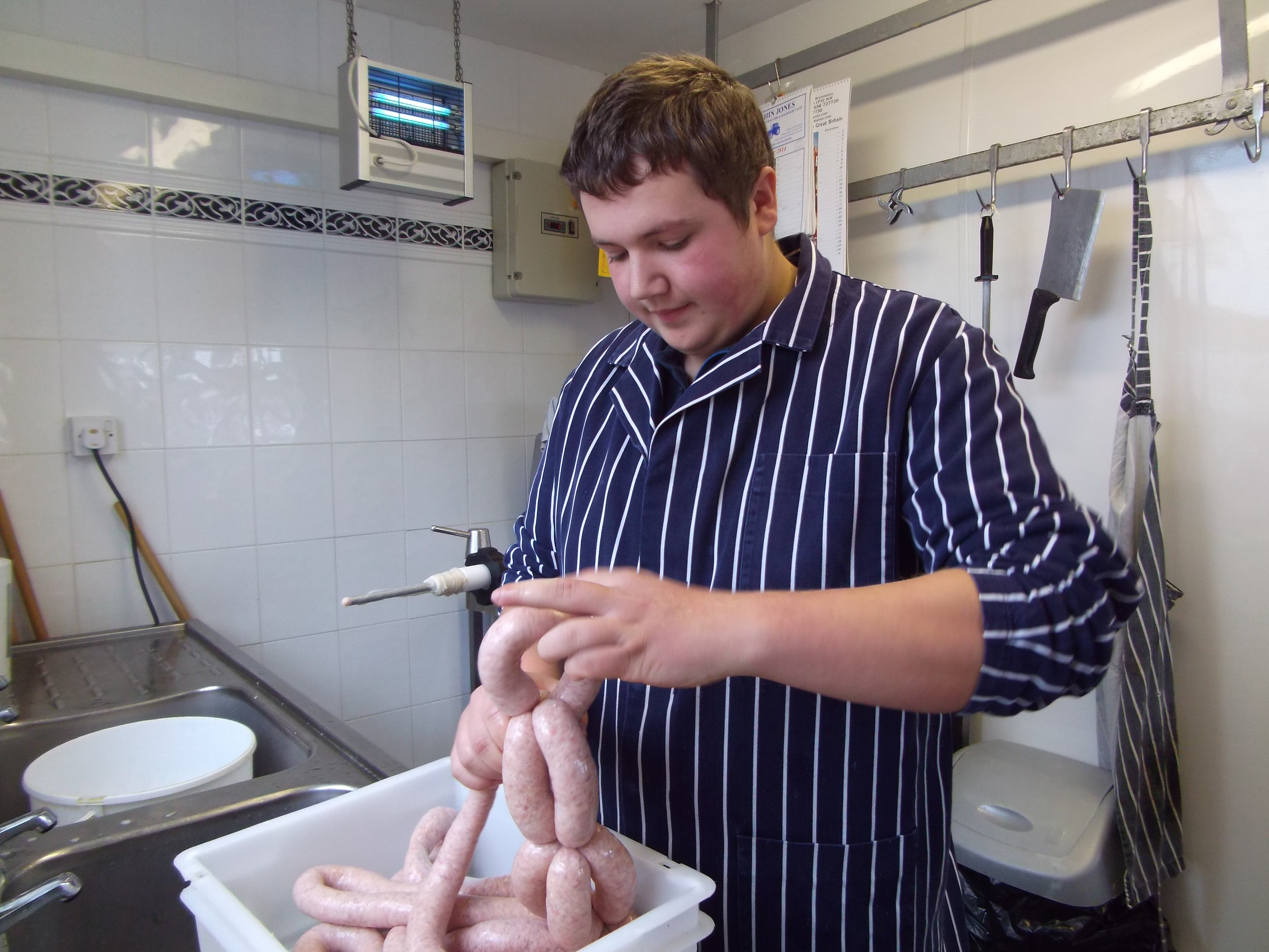 Tying up loose ends- butchers apprentice Sion Jones preparing pork and apple sausages at the family run Llanon butchers