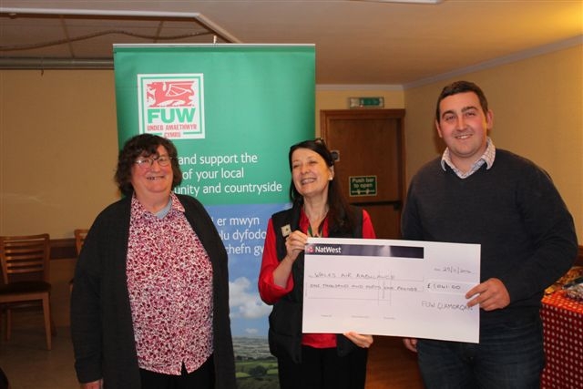 Lee Pritchard hands the £1,041 cheque to Catrin Hall (centre) as Lorraine Howells proudly looks on.