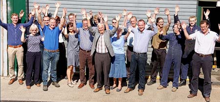 Staff at Quality Equipment (those not out in the field)  raise a cheer for the company’s 50th anniversary