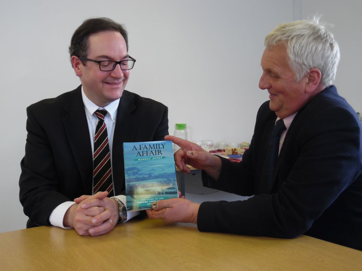 US Counselor for Agricultural Affairs Stan Phillips received a copy of “A Family Affair” from FUW President Glyn Roberts