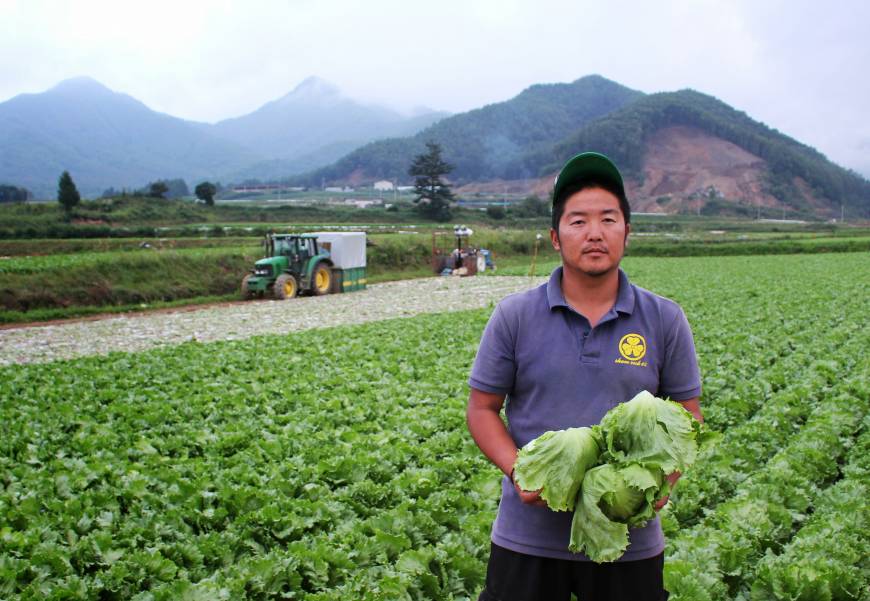 A young farmer displays some of his produce in the village of Kawakami, Nagano Prefecture