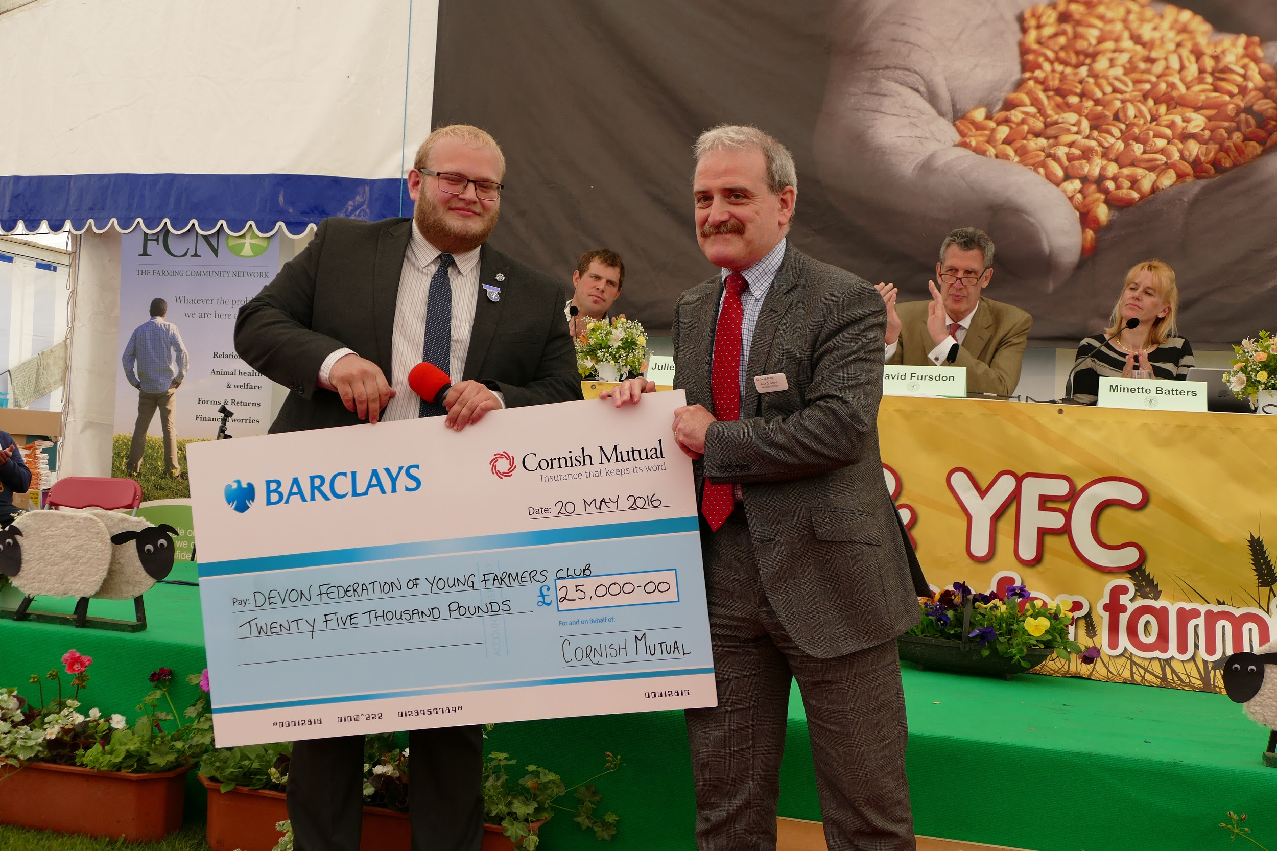 Jake Henson, Devon County Young Farmers County Chairman accepts the cheque on behalf of Devon Young Farmers from Alan Goddard, Managing Director of Cornish Mutual