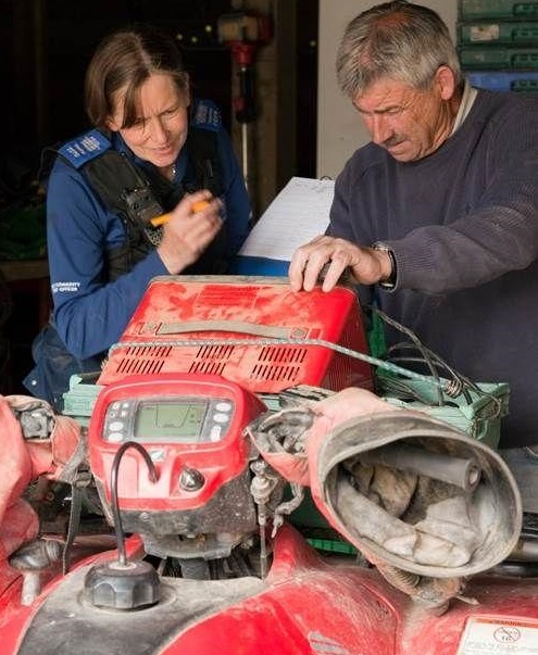 A policeman helps a farmer property mark and register a quad bike (Photo: Avon and Somerset Police)