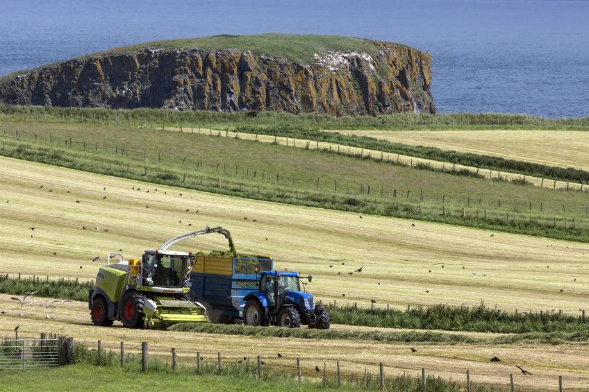 Farmers collect silage in the fields near the village of Ballycastle in County Antrim in Northern Ireland