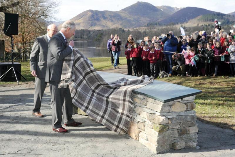 Prince Charles lifts a herdwick wool blanket to reveal the official installation at Crow Park, Keswick