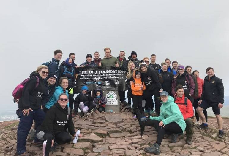 Matt Launder, Dan Launder, George Collins and Gareth Owen pictured with friends, family and supporters after completing the 9 Peaks Challenge