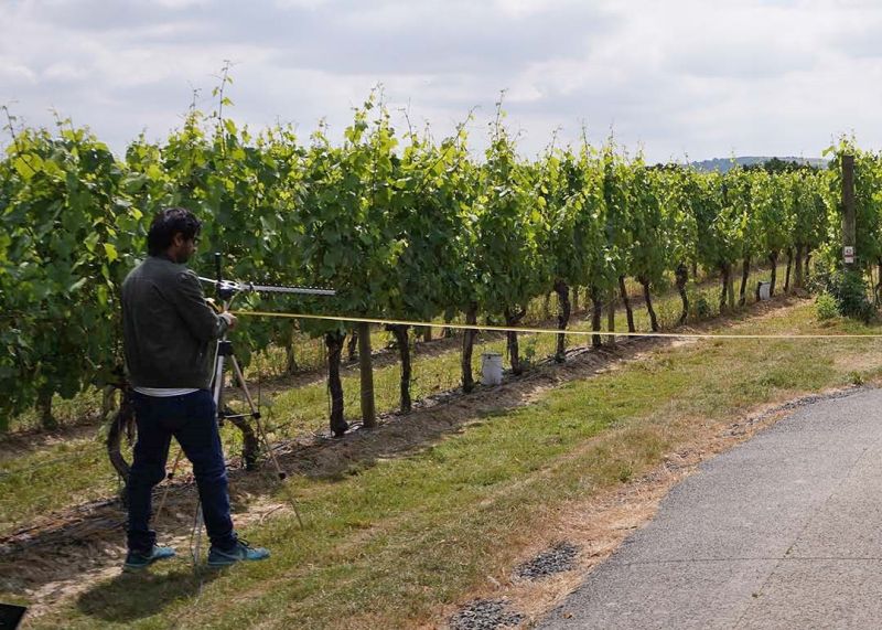 Researchers measuring the distance between sensor device and antenna to explore the relationship between radio frequencies and distance in the field