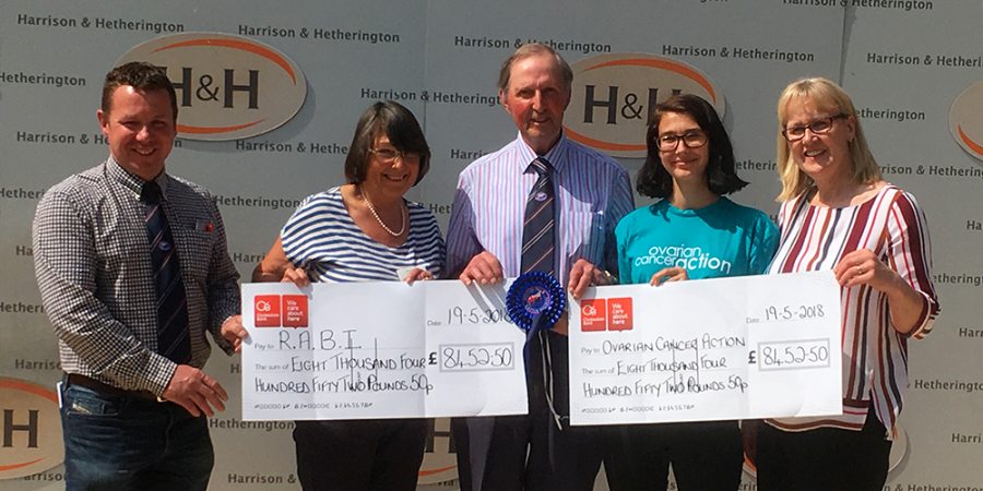 Emyr (centre) presenting cheques to representatives of his two chosen charities following a cattle sale in 2018