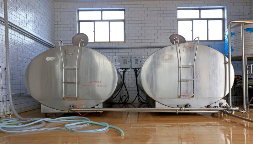 Bulk milk tanks on a dairy farm, as AHDB warns excess supplies are slowing any recovery in farmgate prices
