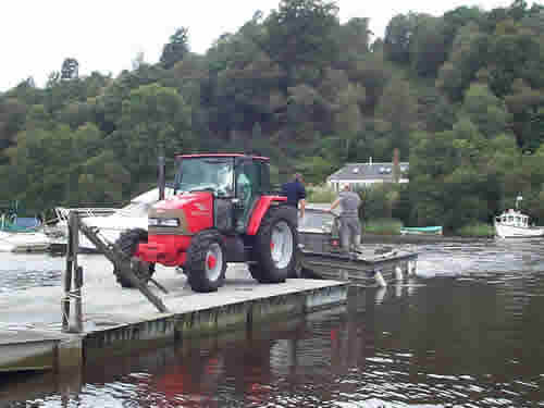 With the tractor safely onboard and the ramp raised, the crew prepares to cast off.